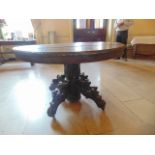 An oak oval pedestal table Flemish early century the top with a gadrooned border, the carved