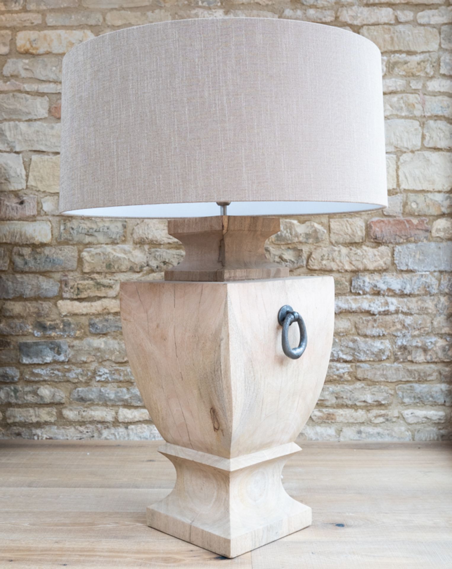 Wooden Lamp: A large, beautifully carved wooden lamp finished in a light natural stain.