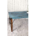 A unique vintage wooden dining table with a striking blue surface Full of texture and rustic style