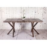 A solid aged iron full size dining table The top is constructed from upcycled metal panels with a
