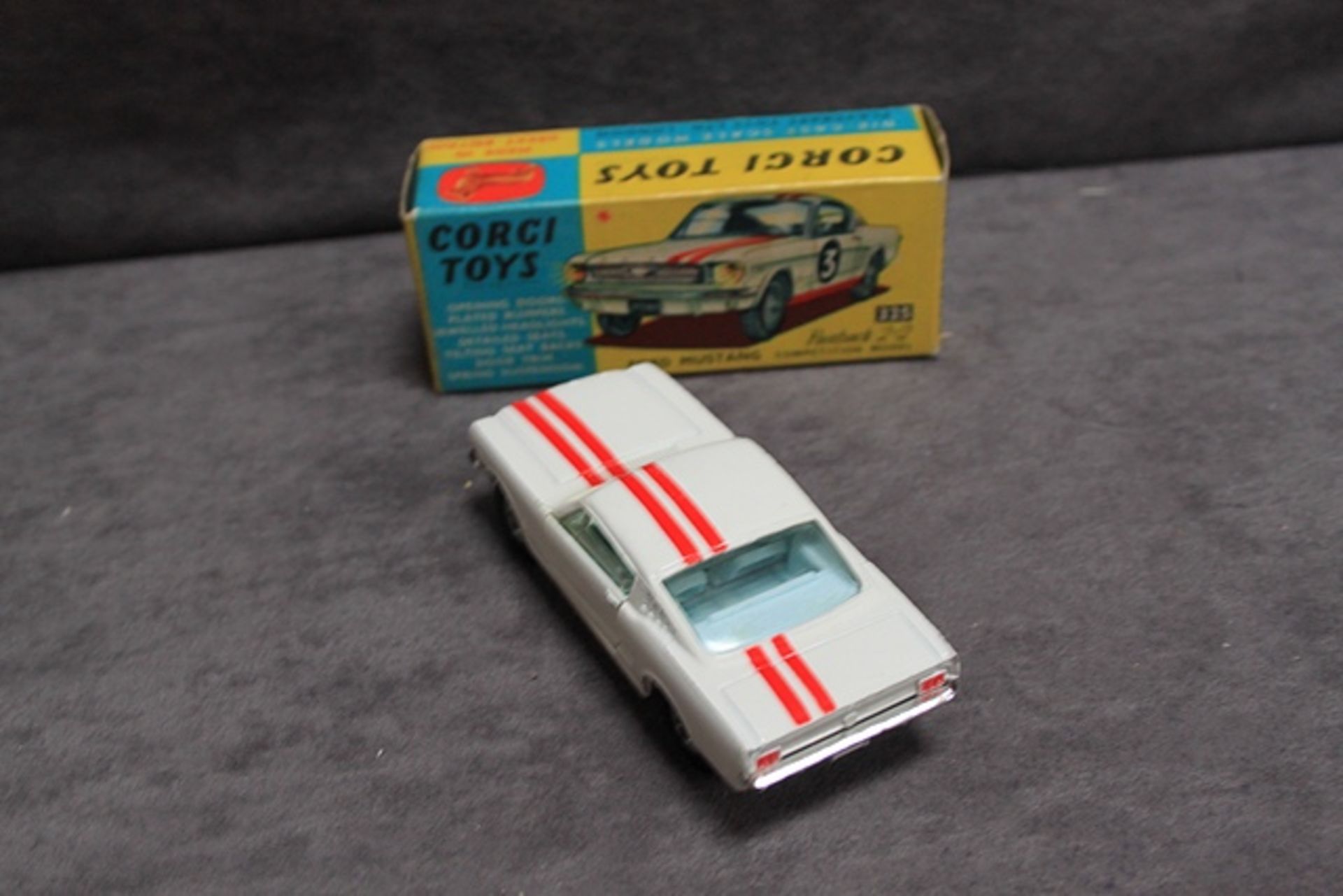 Mint Corgi Toys diecast #325 Ford Mustang fast back 2+2 in white with red stripes and leaflet in