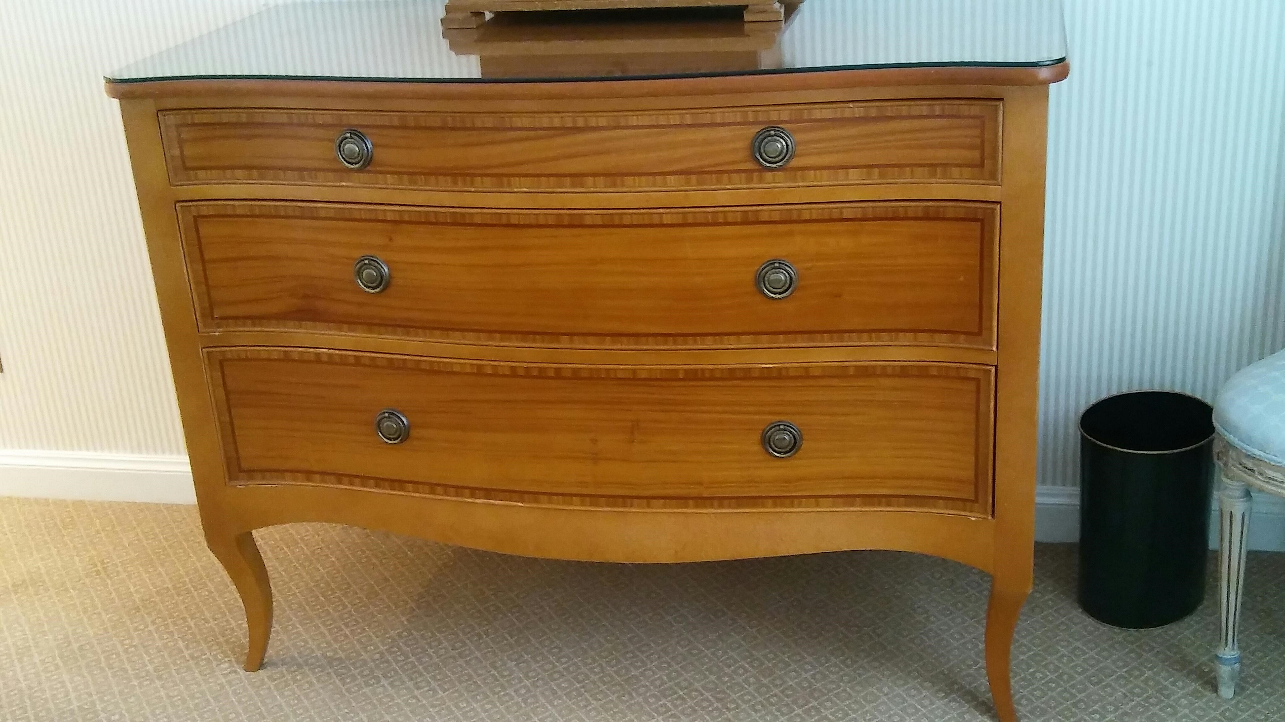 Three drawer chest of drawers with glass top - serpentine shaped front with sabre style front legs