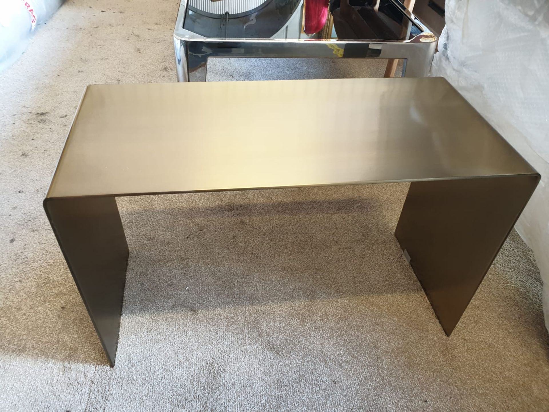 A brushed steel waterfall single piece side table constructed of solid stainless steel in brushed