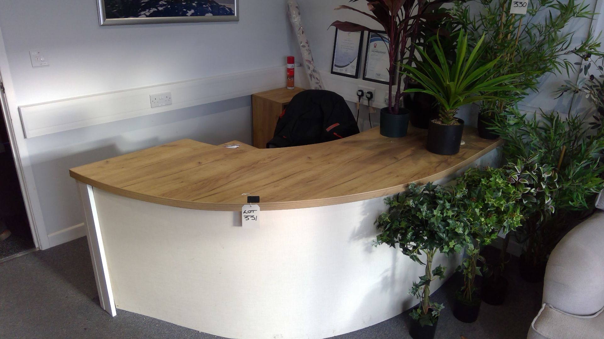 Curved reception desk with pedestal, chair and book shelf