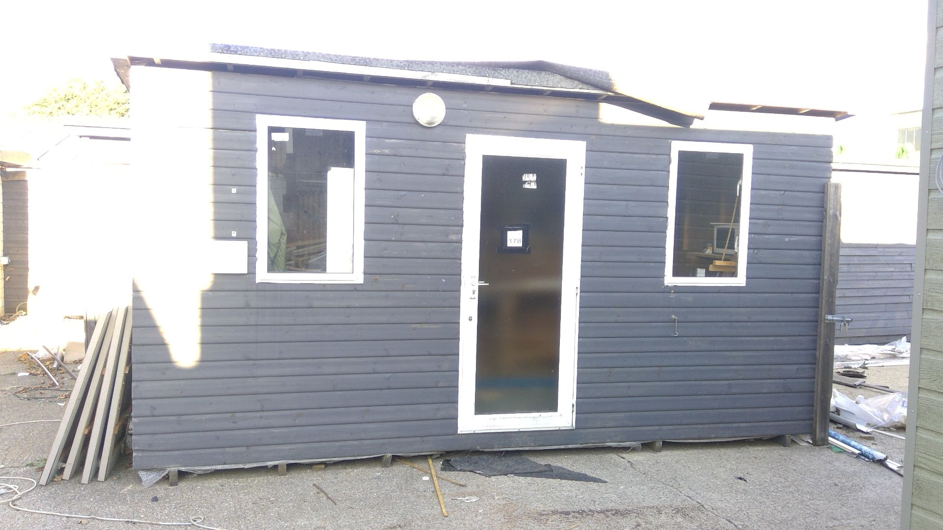 15ft x 8ft timber clad workshop with double glazed units with contents to include benching etc