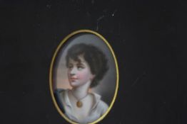 A German painted porcelain plaque, c. 1900, of a young girl wearing a gold locket, oval, unsigned,