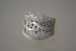 A striking diamond dress ring, formed of wavy bands of diamond points encircling six collet-set