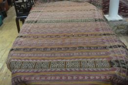 A natural dyed kelim flatwoven rug, with alternating medallion and stylised flowerhead panels,