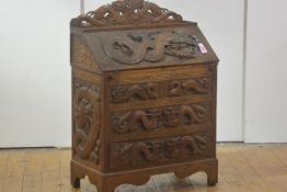 A striking Chinese relief-carved hardwood bureau, early 20th century, the rectangular top with