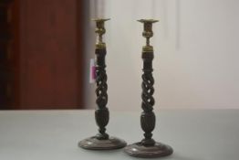 A pair of 19th century carved and turned oak open twist candlesticks, each with brass urn form