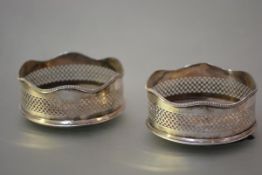 A pair of George III style silver bottle coasters or wine slides, London 1967, each with scalloped