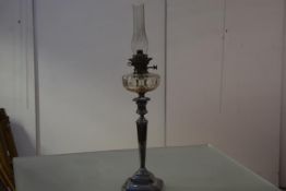 A 19th century silver-plated oil lamp, the cut-glass reservoir over an urn-form finial and