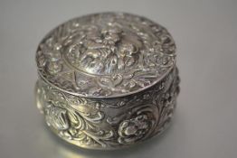 A German 800 silver box, c. 1900, circular, the hinged cover repousse with a cartouche of the Virgin