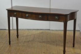 A George III style string-inlaid mahogany side or serving table, of serpentine form, with three