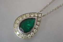 A striking emerald and diamond pendant, the pear-cut emerald collet set within a band of round