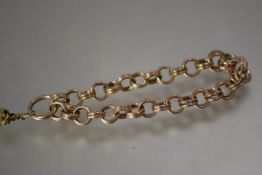 A substantial yellow metal chainlink bracelet, of double ring links, suspending a small fob (element