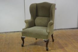 A small George III style mahogany framed wing chair, c. 1900, with outscrolled arms, raised on