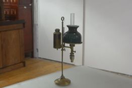 A late 19th century brass student's lamp, of characteristic form, with cased green glass shade.