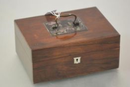 A 19th century rosewood work box, of plain rectangular form, the cover mounted with a Chinoiserie