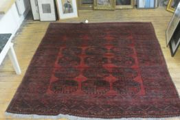 A square Bokhara hall rug, the centre panel with three rows of six medallions enclosed within a