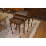 A nest of three walnut coffee table, with scalloped edges, plain friezes, cabriole style legs