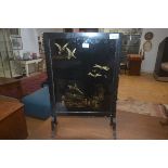 A vintage fire screen with ebonised frame enclosing a panel depicting kingfishers, ducks and