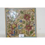 A large Qajar Persian pottery tile, 19thc polychrome painted with flowers and a turquoise border,