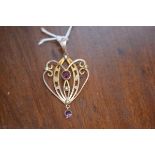 An Art Nouveau pendant with amethyst and seed pearls on yellow metal