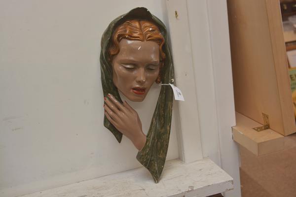 A vintage wall plaque of a woman's head in scarf in painted plaster
