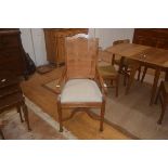 A 19thc colonial style chair, the cane back on shaped arms, upholstered seat, square supports and