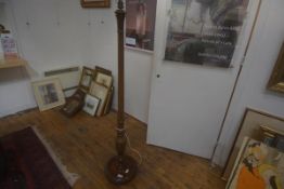 An early 20thc mahogany standard lamp, the carved and fluted column on circular base with carved