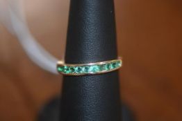 An emerald half hoop eternity ring in 10ct yellow gold, size N/O