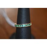 An emerald half hoop eternity ring in 10ct yellow gold, size N/O