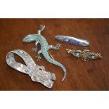 A mixed lot including a white metal bow, a turquoise set gecko, a baby brooch and a yellow metal