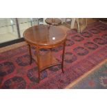 An Edwardian circular rosewood side table, the crossbanded top on square legs with curved ends,