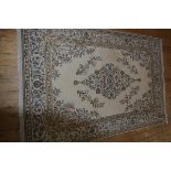 An Indian wool carpet with all over leaf and vine decoration, on ivory field with all over