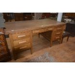 A 1930's/40's oak office desk, the plain rectangular top with single freize drawer, on two banks
