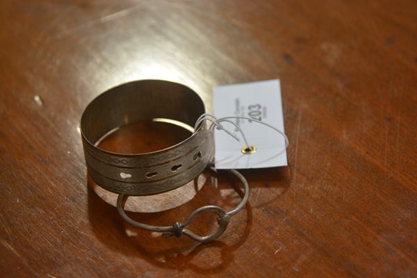 A hallmarked silver engraved bangle and a white metal bangle (2)