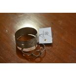 A hallmarked silver engraved bangle and a white metal bangle (2)