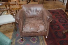A brown leather upholstered tub chair, on square supports