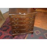 A 19thc style bow fronted walnut chest of drawers, the crossbanded top above a mahogany slide,