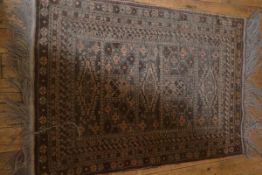 An Afghan prayer rug, the central panel with five panels flanked by flowerhead and geometric border,