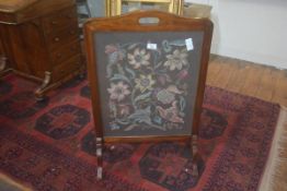 A 1920's/30's mahogany framed fire screen with inset wool work panel