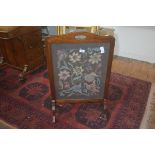 A 1920's/30's mahogany framed fire screen with inset wool work panel