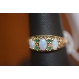 A lady's opal and emerald set dress ring on 9ct gold band