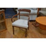 A Regency mahogany carver chair with curved top rail and scroll arms, with stuffover seat, on turned