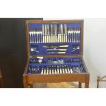 A 1920s oak table canteen, the rectangular hinged top enclosing a suite of Epns flatware including t