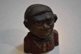 A cast iron Caribbean boy money bank with polychrome decoration (h.12cm), £20-40