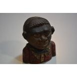 A cast iron Caribbean boy money bank with polychrome decoration (h.12cm), £20-40