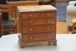 A 19thc oak miniature apprentice style chest, the rectangular top with moulded edge above two short